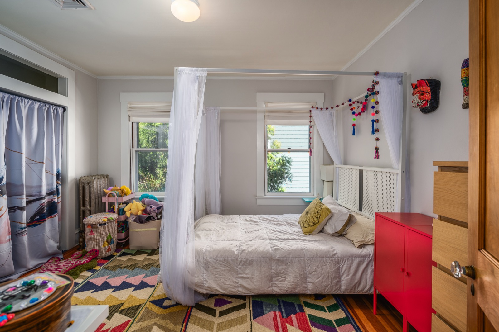 Third bedroom with a full bed, canopy curtain, and a red dresser.