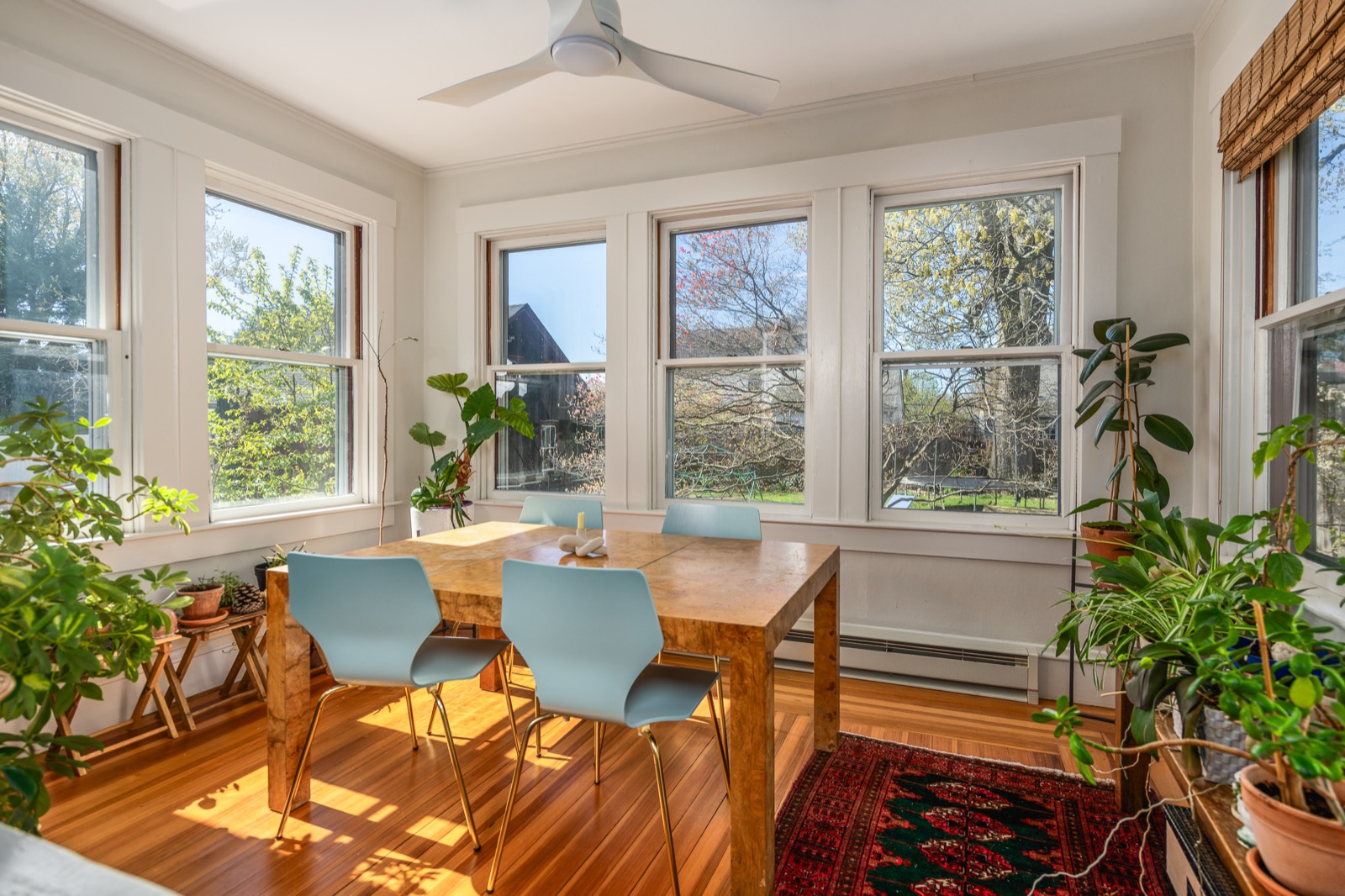 Sunroom from a second angle with a burlwood breakfast table and four chairs.