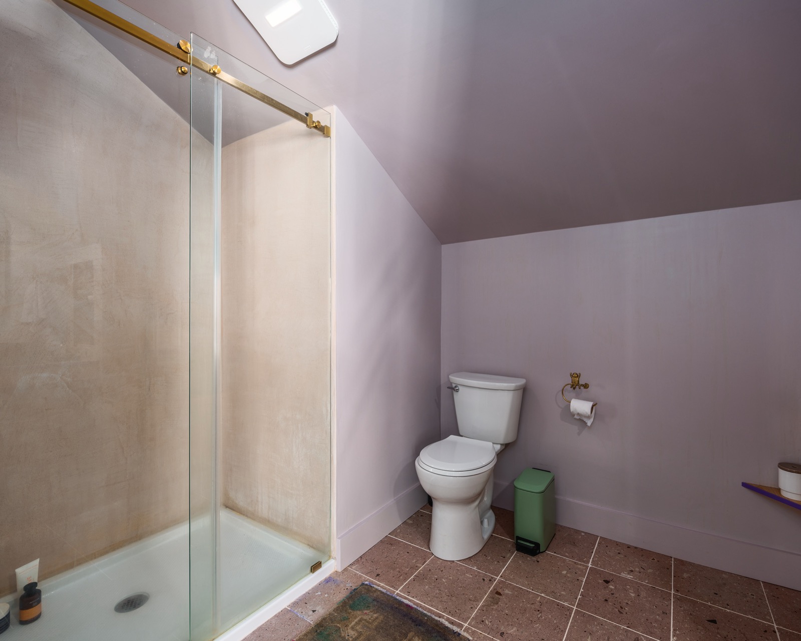 Walk-in shower in the primary en-suite with brass fixtures.